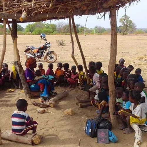 a group of children sitting on the floor in a outside classroom