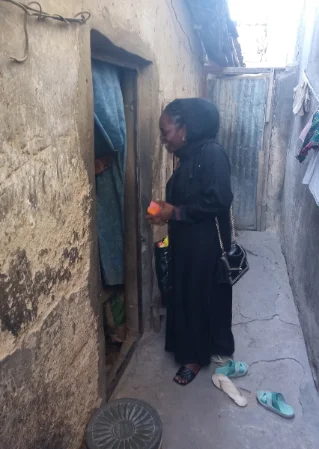 a lady in black waiting for a child to come out of the of a house